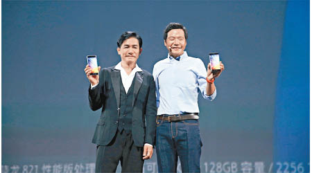 代言人梁朝偉（左）現身北京發布會，與小米董事長雷軍（右）合照。