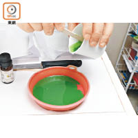 製作葱花，將綠色的食用色素加入肥皂液，一邊攪拌，一邊調校顏色深淺。另調配出花生醬及甜醬顏色。