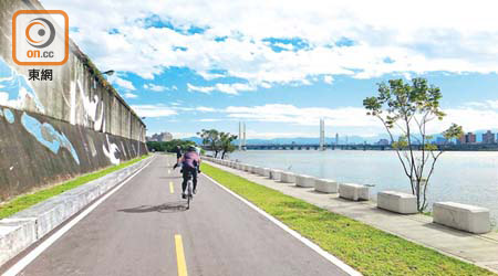 不少旅客利用YouBike在台北觀光，其中一大熱門路線是社子島環島單車道，一面是特色塗鴉，一面是河濱美景。
