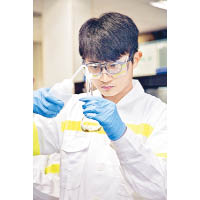 李應龍在南丫發電廠化學化驗室學習如何測試廢水樣本的酸鹼度。