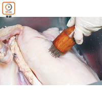 在豬肺上刺孔，並按壓豬肺，加快將潺水、血水沖走。