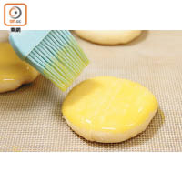 6. 把麵糰輕輕按扁，面層掃上蛋汁。