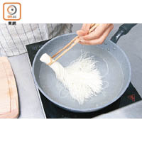 2. 用橡筋將素麵的一端束起，放入滾水煮3分鐘，用冰水過冷河後備用。