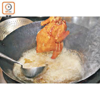 預熱焗爐，把雞放入焗爐後以120℃焗40分鐘至9成熟，將約160℃滾油淋雞至變成金黃色。