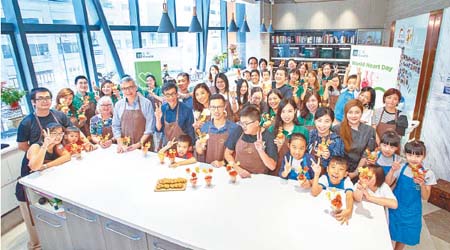 於健康烹飪班上，宏利香港首席行政總監萬士家（前排左四）與兒童心臟基金會的受惠者一起製作健康食品。