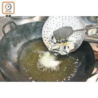 2.預熱滾油約180℃，將南瓜片撲上一層薄薄的生粉炸至金黃色，盛起備用。