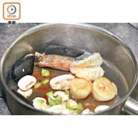 蘑菇切片，放入煎香的海鮮中，炒至軟身。