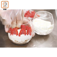 用紅桑子圍着玻璃杯作裝飾，把蛋糕捏碎放在中間，面層唧忌廉，以紅桑子及朱古力作點綴即成。