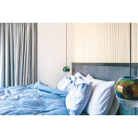主人房<br>米白色牆飾襯上灰黑色床板，對比強烈，床頭配合小巧球形吊燈，成功營造出舒適的環境。