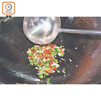 油鑊燒熱後，先要爆香葱花、辣椒及蒜蓉，以吊出外婆菜的香氣。