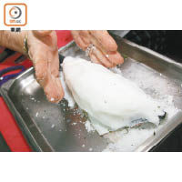 2. 用鹽覆蓋鱸魚，面層再鋪滿混合了蛋白的海鹽。