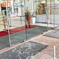 商場的玻璃門（紅框示）塌下破碎傷人，警員在現場調查。