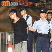 另一名被捕男子由警員帶署。
