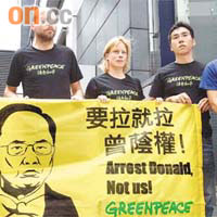 左起：四名被捕「綠色和平」成員及團體項目主任古偉牧（右一）昨亦拉起橫額在灣仔警察總部外示威。	（伍鎮業攝）
