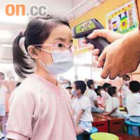 豬流感繼續蔓延，老師每天為學童量體溫，留意他們的健康狀況。（梁耀榮攝）