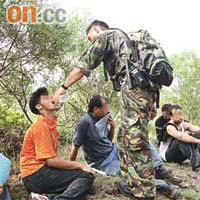南亞裔人蛇被截獲時已筋疲力竭，警員餵水解渴。	（郭垂垂攝）