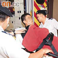 強闖警署內部的男子被制服後，由救護員送院檢驗。	（馮戈攝）