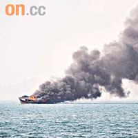 起火漁船黑煙沖天，油躉駛近拯救船員。	（圖片由讀者提供）