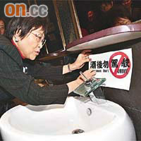 劉健儀在酒吧洗手間貼上「酒後勿駕駛」貼紙。	（盧志燊攝）