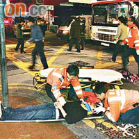 青年遭巴士撞飛受傷倒地，救護員到場為他急救。	（胡德威攝）