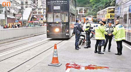 肇事電單車的車輪楔入電車路軌出事，警方在現場調查。