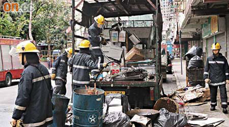 消防員移開車上燒毀的金屬廢料調查。	（林少兒攝）
