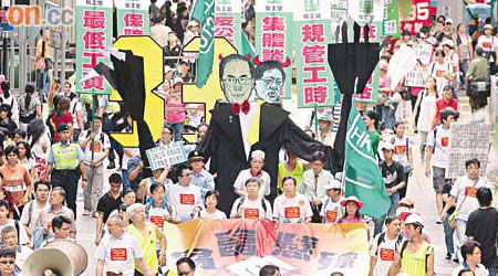 勞工團體高舉曾蔭權及張宇人的「官商連體怪」遊行往政府總部。	（高嘉業攝）