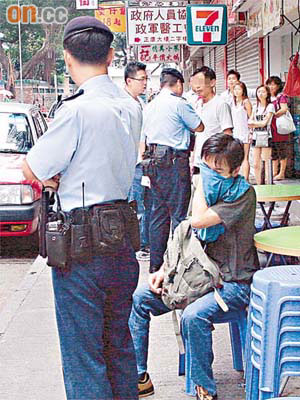 警員拘捕涉嫌毆人的店東，受傷食客則坐在櫈上等候送院治療。	（曾志恒攝）