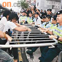 示威者在中聯辦門外試圖搶去警方的鐵馬，雙方對峙兩個多小時，示威者始散去。（伍鎮業攝）