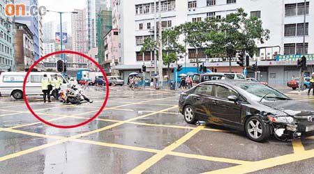 警方電單車（圓圈示）與私家車相撞後翻側。
