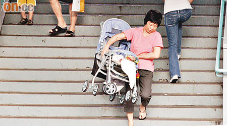 溫女士（抱嬰兒車者）表示，每天帶孫兒到樂富天台花園都要抱嬰兒車上落，非常吃力。	（梁耀榮攝）