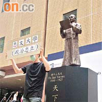 有示威者昨到浸大孫中山銅像前，舉牌向中文大學抗議。	（鍾麗珊攝）