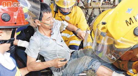 被鐵枝壓傷的工人，由救護員急救。	（馮戈攝）