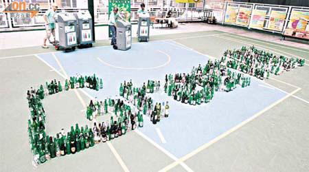 「玻璃再生璀璨」計劃的開幕禮上，協會用廢玻璃酒樽砌出「Green HK」字句。	（高嘉業攝）