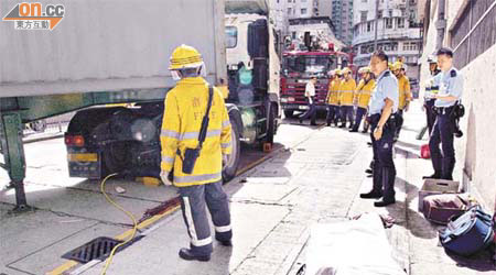 遭貨櫃車輾斃的老婦，屍體被移至路旁。	（曾紹良攝）