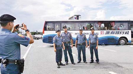 在屠殺慘劇發生翌日，五名菲國警察以康泰旅巴為背景相互拍照。