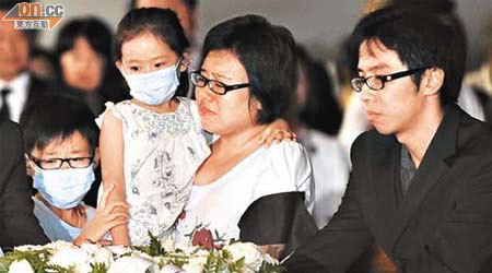 傅卓仁的靈柩運返本港時，其妻子帶同一對子女在機場迎領。