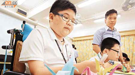 殘障學童專心學習摺紙鶴，希望小小動作能化作最大的祝福。	（蘇文傑攝）