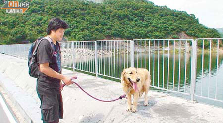 狗主見愛犬平安獲救，喜上眉梢。	（翁火攝）