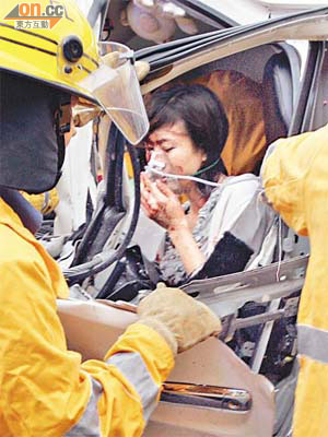 受傷被困女乘客需用氧氣罩協助呼吸。	（梁國雄攝）