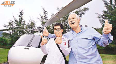 患腦瘤的文耀（左）與攝影大師恩亞祖貝特杭登上直升機進行高空拍攝。