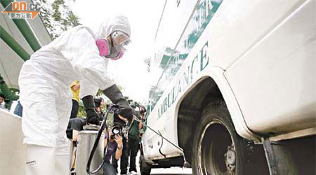 防疫人員為接載病患者進出度假村的救護車徹底消毒。	（陸智豪攝）