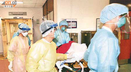 醫護人員穿上防護裝備，將患禽流感女病人由屯門醫院，送往瑪嘉烈醫院。	（朱先儒攝）