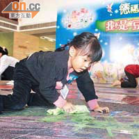 進入決賽的女童需把倒滿油彩的地板擦乾淨，小女孩全情投入。