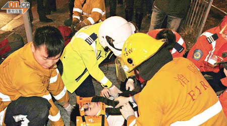 救護員為受傷青年包紮及固定頭部。	（余宏基攝）