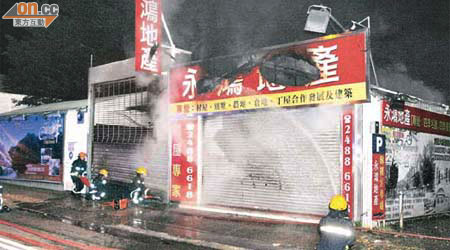 地產代理公司遭縱火，消防員開喉灌救。	（楊日權攝）