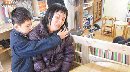 庾太接收東方日報慈善基金及恒基地產合共捐出的四萬元善款，灝霖則在旁安慰痛哭的母親。