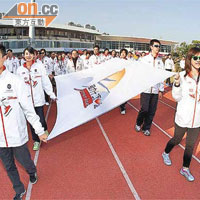 中港精英運動員手持徽旗進入會場，楊威（前排左）及蔡曉慧（前排右）負責打頭陣。