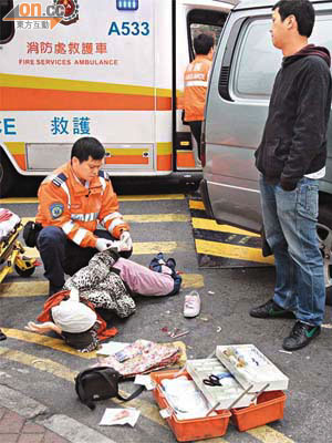 救護員為受傷女子急救，肇事司機一臉擔憂。