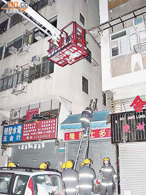 消防員架起鐵梯爬上屋頂救火。	（葉嘉文攝）